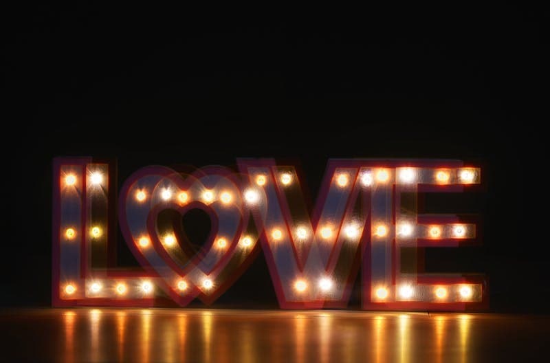 Illuminated marquee letters spelling LOVE at an event